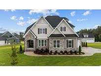 Two-story home with stone accents and a three-car garage at 25 Cotton Fields Ln # 29, Fuquay Varina, NC 27526