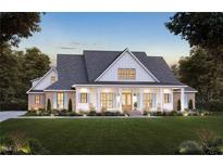 Two story farmhouse with front porch, brick accents, and landscaped lawn at 6604 Deermont Ct, Gibsonville, NC 27249