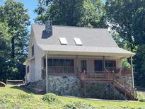 House exterior featuring stone accents, a covered porch, and mature trees at 901 Tanglewood Dr, Siler City, NC 27344