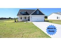 Move-in ready home with gray siding, blue accents, and a two-car garage at 123 Johnson Ridge Way, Four Oaks, NC 27524