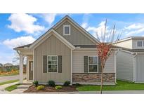 Craftsman style home with gray siding, stone accents, and a welcoming front porch at 723 Dorset Stream Dr, Fuquay Varina, NC 27526