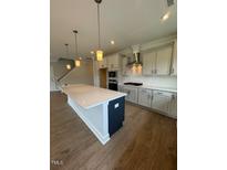 Modern kitchen with large island, stainless steel appliances, and light cabinets at 317 Kavanaugh Rd, Wake Forest, NC 27587
