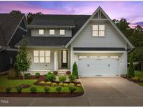 Two story home with white siding and a two car garage at 414 S Cross St, Youngsville, NC 27596