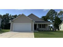 Beige house with white garage door and stone accents at 32 Oakfield Trace Dr, Four Oaks, NC 27524
