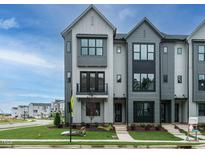 Modern three-story townhome with gray siding, black windows, and a front porch at 1140 Cottonsprings Dr, Wendell, NC 27591