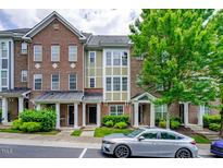 Brick townhome with 3 levels, front porch, and landscaping at 128 Dove Cottage Ln, Cary, NC 27519