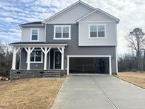 Two-story home with gray siding, white accents, and a two-car garage at 428 Fast Pitch Ln, Four Oaks, NC 27524