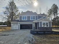 Two-story house with gray siding, stone accents, and a two-car garage at 7404 Prato Ct, Wendell, NC 27591