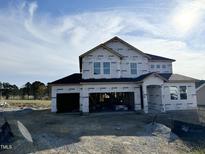 Two-story house under construction, featuring a large garage and a dark brown roof at 644 Barbour Farm Ln, Four Oaks, NC 27524