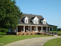 Brick ranch house with dormer windows, front porch, and a long driveway at 334 Ira B Tart Rd, Dunn, NC 28334