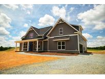 Gray farmhouse-style home with a gravel driveway and large yard at 6030 Preacher Hayes Rd, Mebane, NC 27302