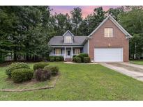 Brick house with a two-car garage and well-maintained lawn at 140 Applegate Dr, Franklinton, NC 27525