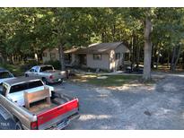 Single story home exterior surrounded by trees at 1612 Us 64, Apex, NC 27523