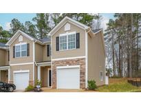 Tan two-story townhome with a white garage door and stone accents at 2833 Egert Dr, Haw River, NC 27258