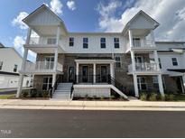 Two story townhome with white siding and brick accents at 11549 Helmond Way # 102, Raleigh, NC 27617
