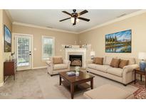 Cozy living room featuring a fireplace, comfy seating, and plenty of natural light at 114 Wembley Dr, Clayton, NC 27527