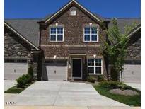 Two-story townhome with brick and stone exterior, two-car garage, and a well manicured lawn at 1055 Talisker Way # 19, Burlington, NC 27215