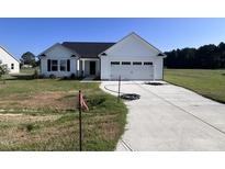 Newly built home with white siding and two-car garage at 231 Lotus Ave, Smithfield, NC 27577