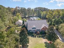 Brick home on a wooded lot with a pond at 3313 Overhead Ct, Willow Springs, NC 27592