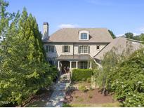 Brick two-story house with stone accents, a walkway, and landscaping at 122 Highclere Ln, Cary, NC 27518