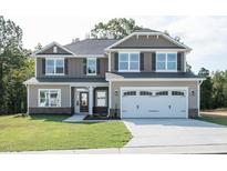 Two-story house with a large white garage door and landscaping at 168 Newport Lndg, Garner, NC 27529