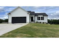 White house with black garage doors and landscaped lawn at 749 Sherrill Farm Dr, Benson, NC 27504