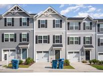 Three-story townhouses with gray siding and two-car garages at 1109 Pale Moss Dr, Durham, NC 27704