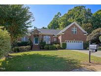 Brick home with two-car garage and landscaped yard at 12417 Fieldmist Dr, Raleigh, NC 27614