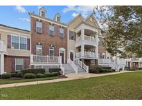 Brick three-story townhouse with a front porch and landscaping at 10410 Sablewood Dr # 111, Raleigh, NC 27617