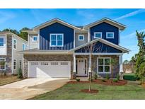 Two-story home with blue and stone exterior, two-car garage, and landscaping at 524 Kings Lake Way, Durham, NC 27703