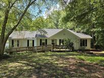 White ranch house with a ramp and large trees in the front yard at 7613 Secluded Acres Rd, Apex, NC 27523