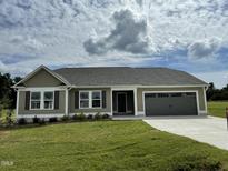 Ranch-style home with a two-car garage and landscaped yard at 152 Lotus Ave, Smithfield, NC 27577