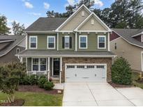 Two-story house with green siding, stone accents, and a two-car garage at 609 Meadowgrass Ln, Wake Forest, NC 27587