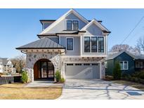Modern two-story home with stone accents, a metal roof, and a paved driveway at 1610 Carson St, Raleigh, NC 27608