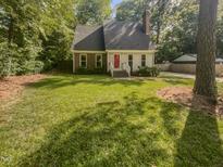 Brick ranch home with a red door and well-maintained lawn at 1517 Wiljohn Rd, Garner, NC 27529