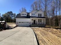 Two-story house with a white exterior, two car garage, and a long driveway at 87 Lupin Dr, Smithfield, NC 27577