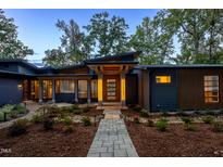 Modern home exterior with a lighted walkway and landscaping at 23930 Cherry, Chapel Hill, NC 27517
