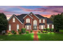 Two story brick house with a landscaped yard at dusk at 4600 Scottland Dr, Mebane, NC 27302