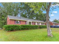 Brick ranch house with a well-manicured lawn and mature trees at 2509 Mckinney St, Burlington, NC 27217