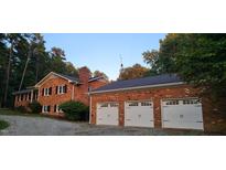 Brick home with a three-car garage and mature trees at 7610 Buckhorn Rd, Hillsborough, NC 27278