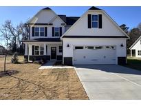 Two-story farmhouse style home with a white exterior, black accents, and a two-car garage at 49 Lupin Dr, Smithfield, NC 27577