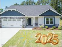 Two-story home with blue siding, stone accents, and a two-car garage at 55 Streamline Ct, Lillington, NC 27546