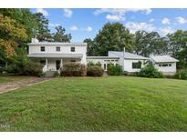 Two-house property with large yard, showcasing a white farmhouse and modern addition at 1021 Dimmocks Mill Rd, Hillsborough, NC 27278