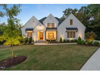 Two-story white brick home with landscaped lawn at dusk at 60 Citori Ct, Pittsboro, NC 27312