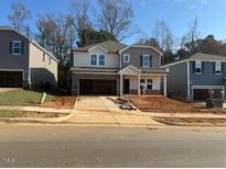 Two-story house with gray and beige siding, two-car garage, and landscaping at 305 Squirrel Oaks Ln, Garner, NC 27529