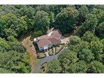Luxury home nestled in a wooded lot, showcasing a grand exterior and landscaping at 6300 Swallow Cove Ln, Raleigh, NC 27614