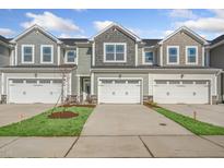 Three-unit townhouse building with white garage doors and landscaping at 211 Anise Ln, Garner, NC 27529