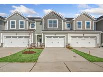 Three-unit townhome building with attached garages and landscaping at 219 Anise Ln, Garner, NC 27529