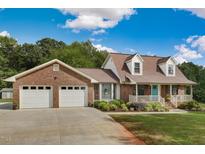 Brick ranch house with attached two-car garage, front porch, and landscaped yard at 3215 Mansfield Rd, Burlington, NC 27217