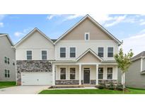 Two-story home with beige and white siding, stone accents, and a two-car garage at 260 Umstead St, Sanford, NC 27330